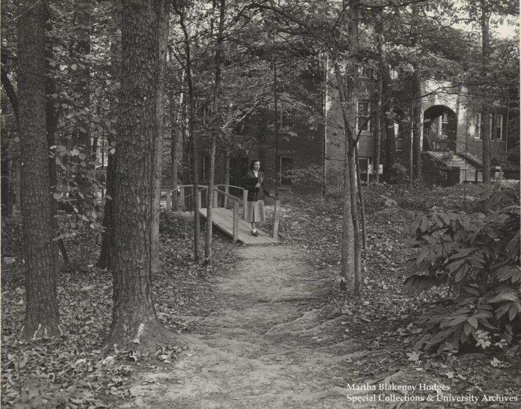 Historical Peabody Park image of a student walking across a footbridge. Circa 1949.